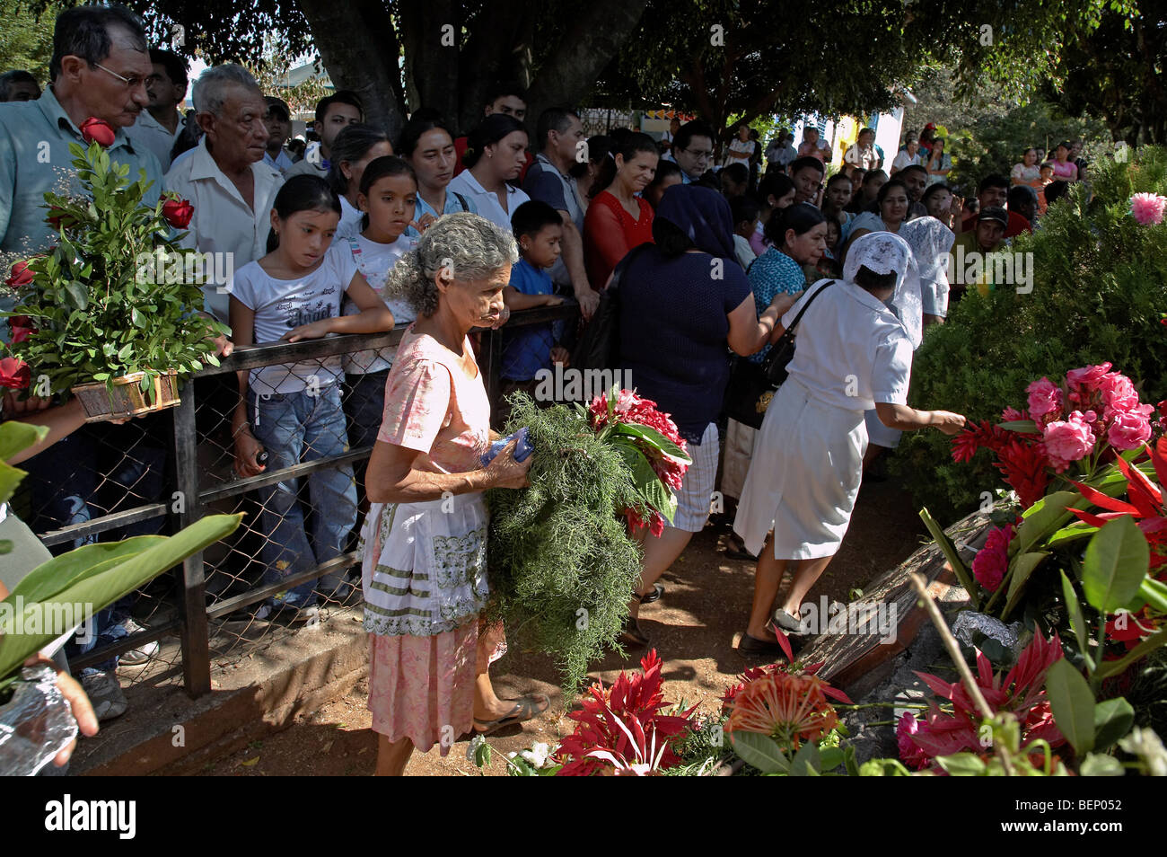 EL SALVADOR  El Mozote, site of the massacre of children in 1981. Laying flowers at grave site for victims. Stock Photo
