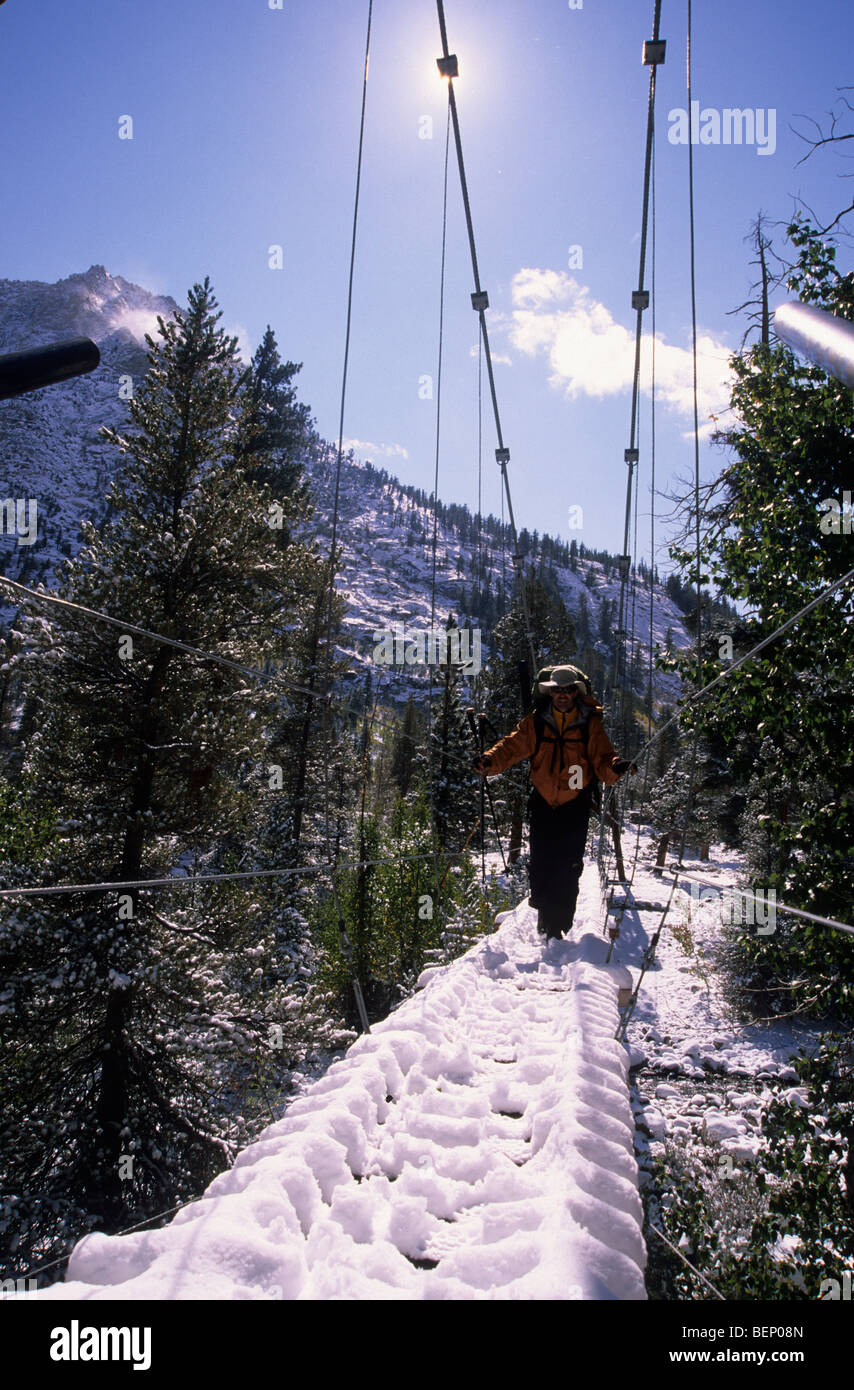 Man crossing suspension bridge Stock Photo - Alamy
