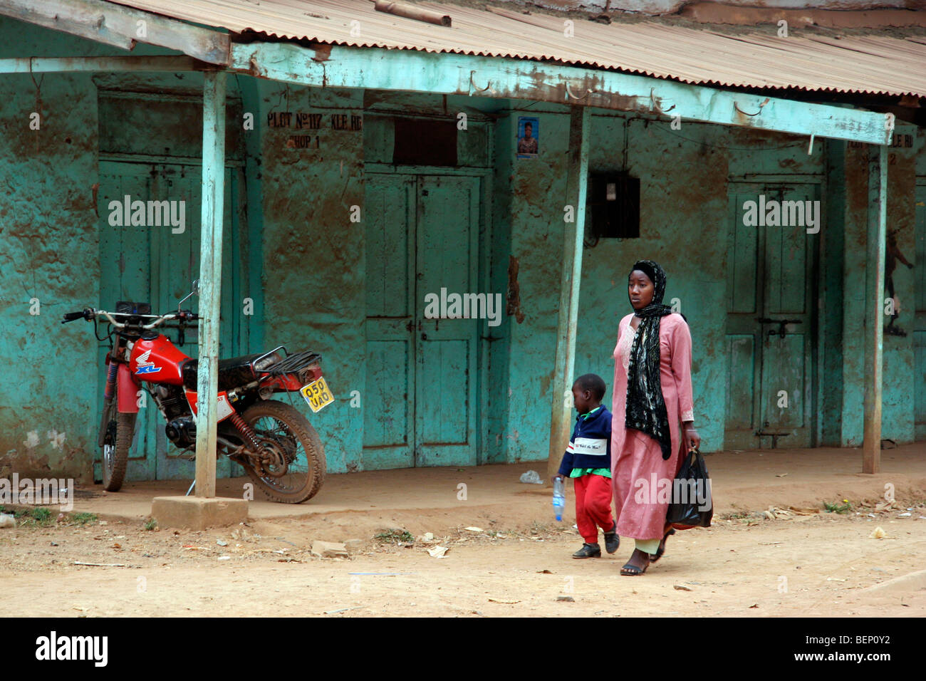 Street scene showing black mother and child walking in village in Uganda, Africa Stock Photo