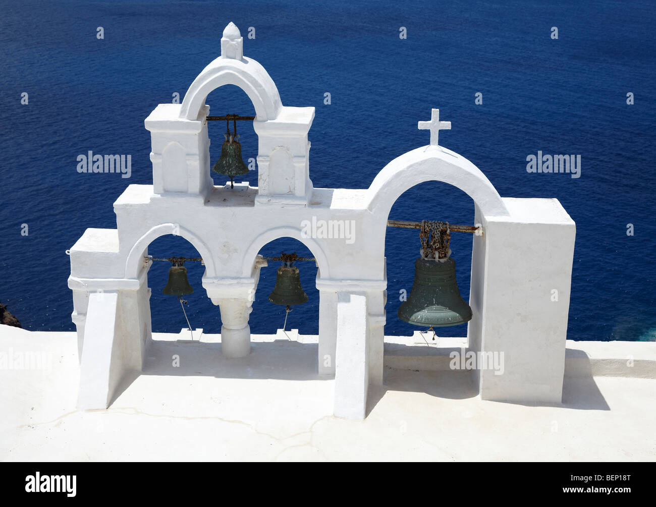 Greek Church bell towers over looking the Aegean sea Stock Photo
