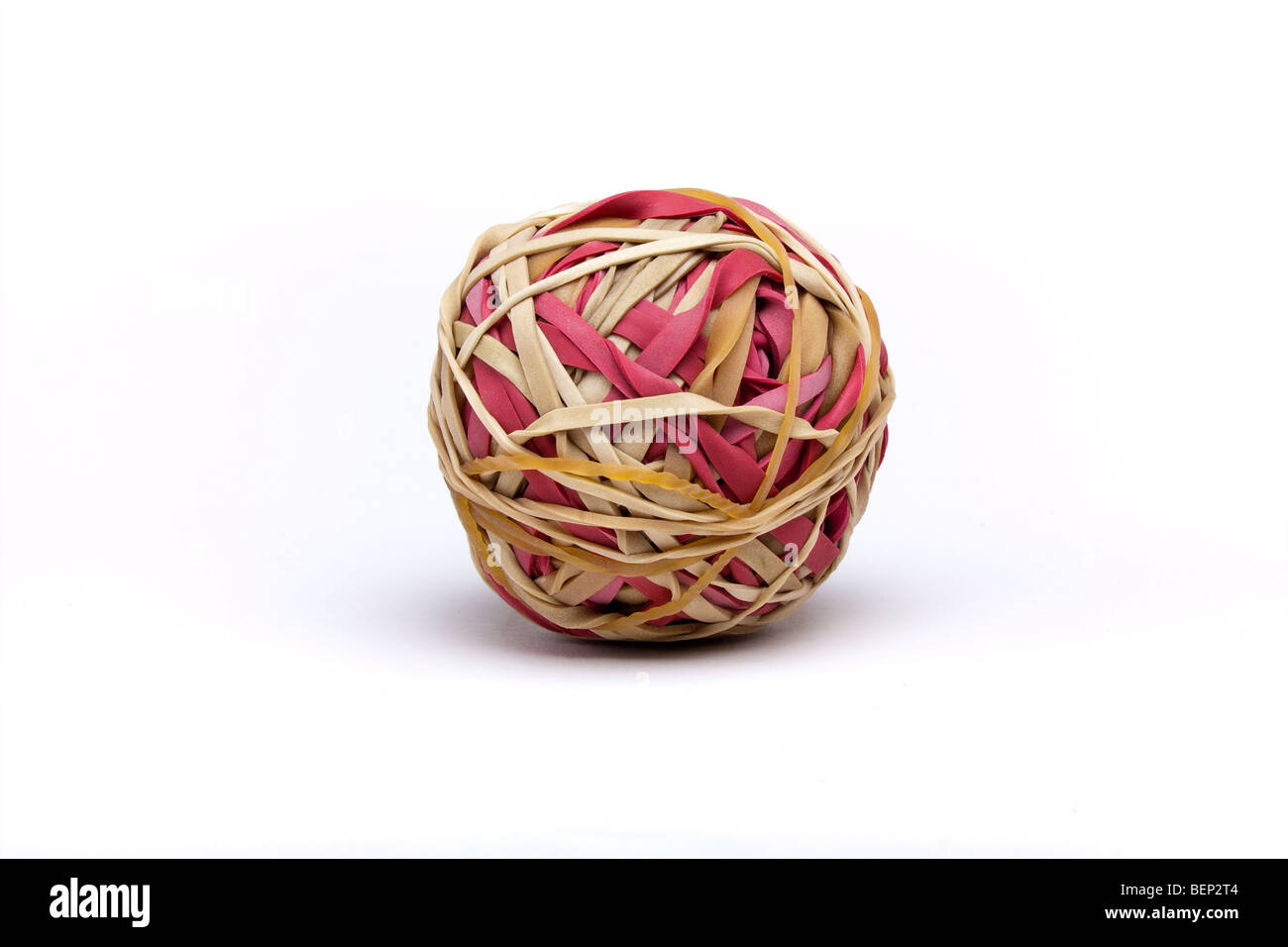 Ball of natural and red coloured rubber bands includes clipping path Stock Photo
