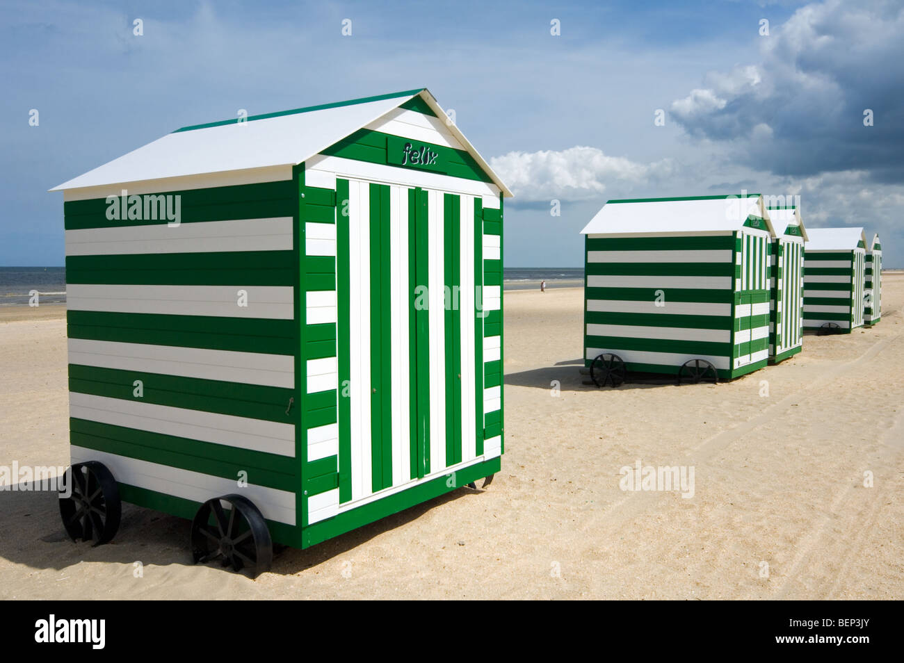 Row Of Colourful White Green Striped Beach Cabins On Wheels Along