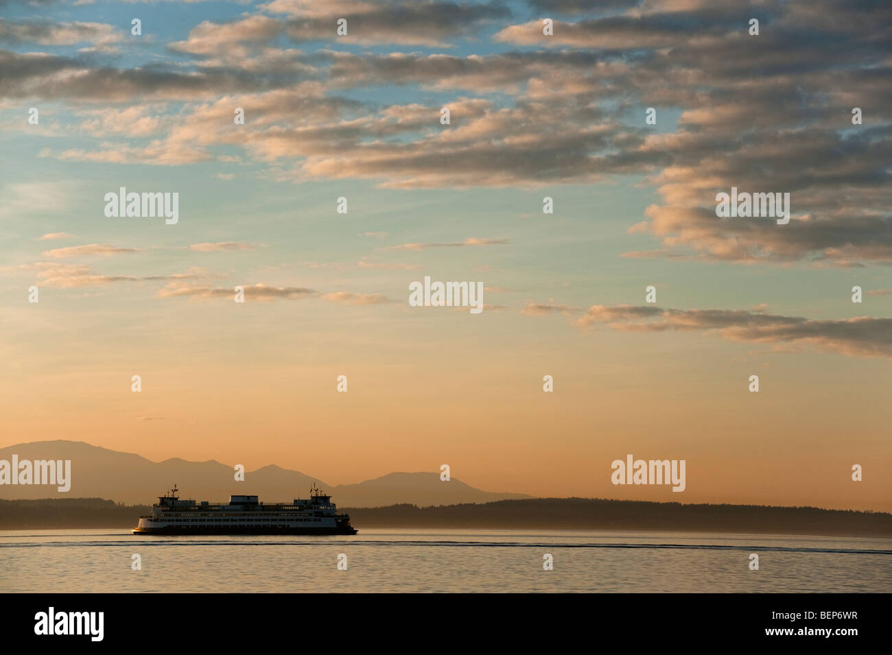 At sunset, one of Seattle's ferry boats makes it's way across Elliott Bay towards Bainbridge Island on the Olympic Penninsula. Stock Photo