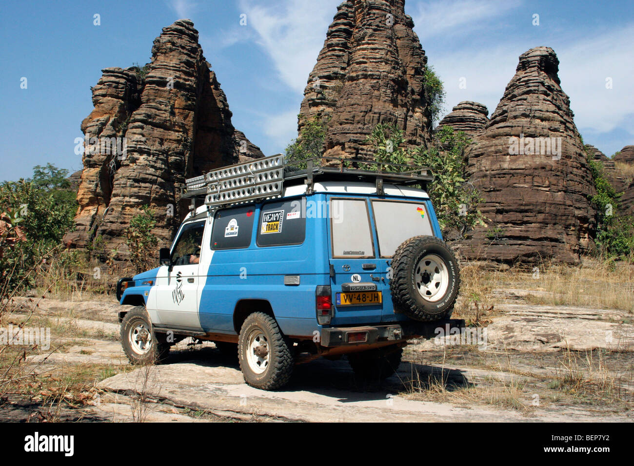Four-wheel drive vehicle and the sandstone rock formations called Dômes de Fabédougou near Banfora, Burkina Faso, West Africa Stock Photo