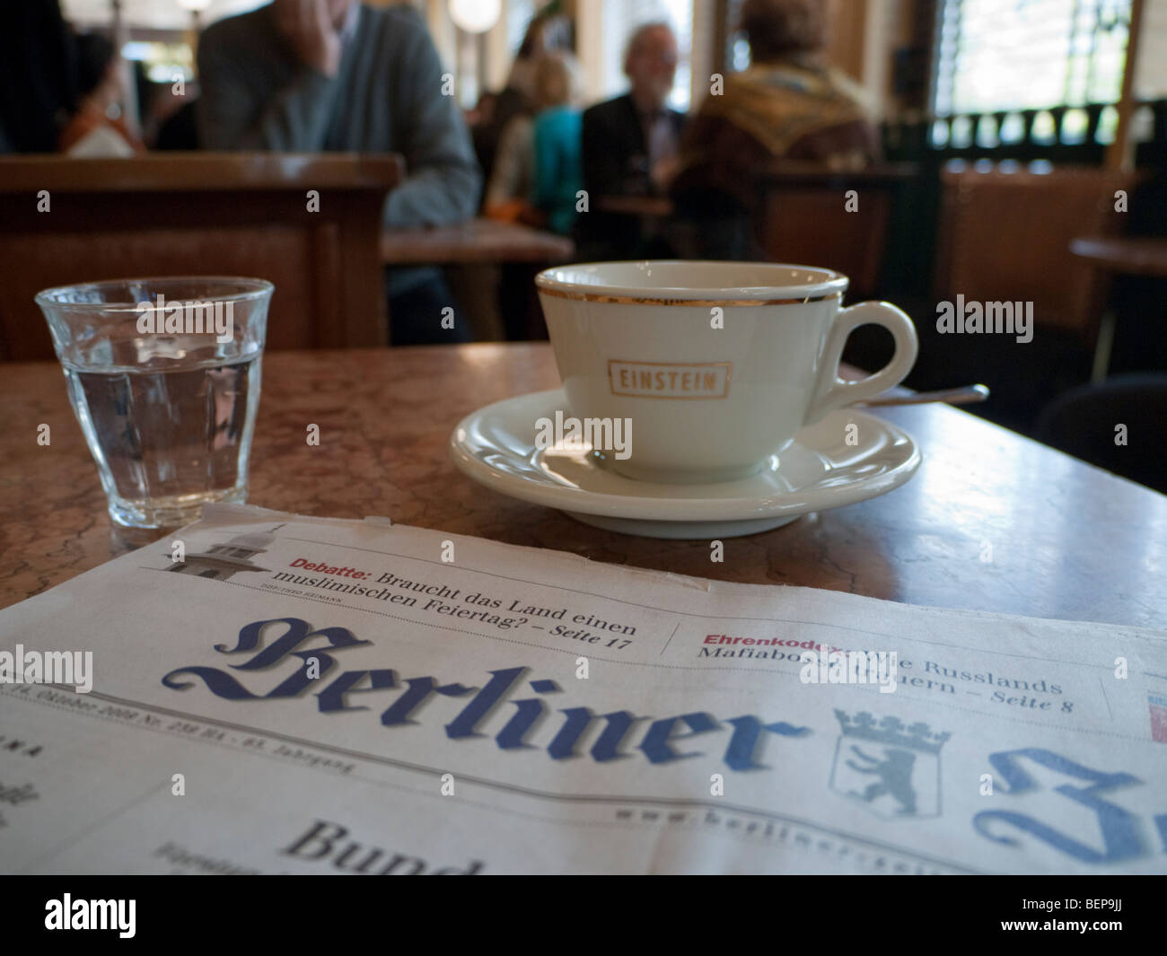 Detail of Berlin newspaper and cup of coffee at famous Cafe Einstein on Unter Den Linden in Berlin Germany Stock Photo