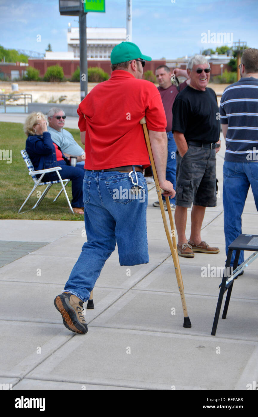 Man with amputated leg uses crutches to move Stock Photo