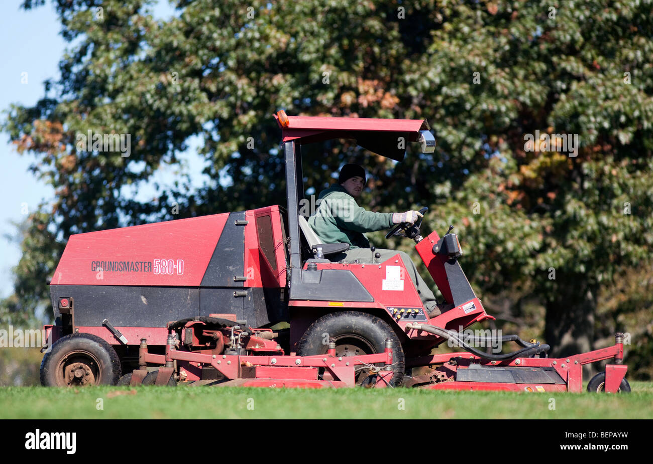 A grounds keeper mowing with a large toro mower. Stock Photo