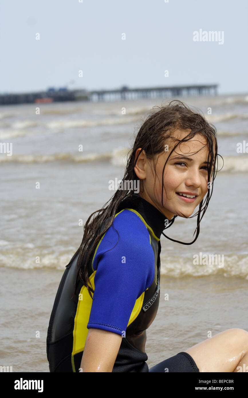 girl sitting on a beach at an English resort in winter Stock Photo