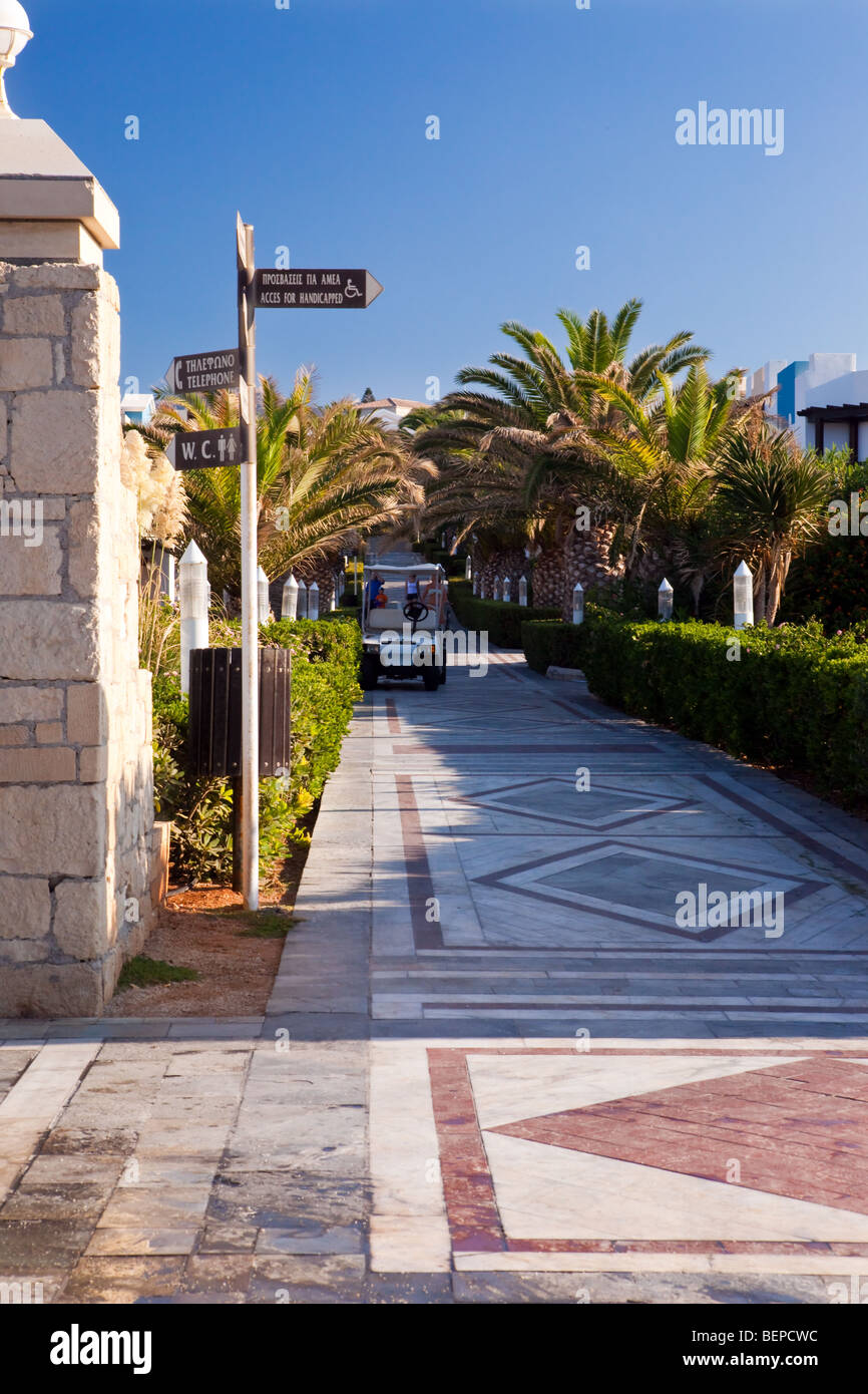 Territory of hotel with a path, palm trees and country houses Stock Photo