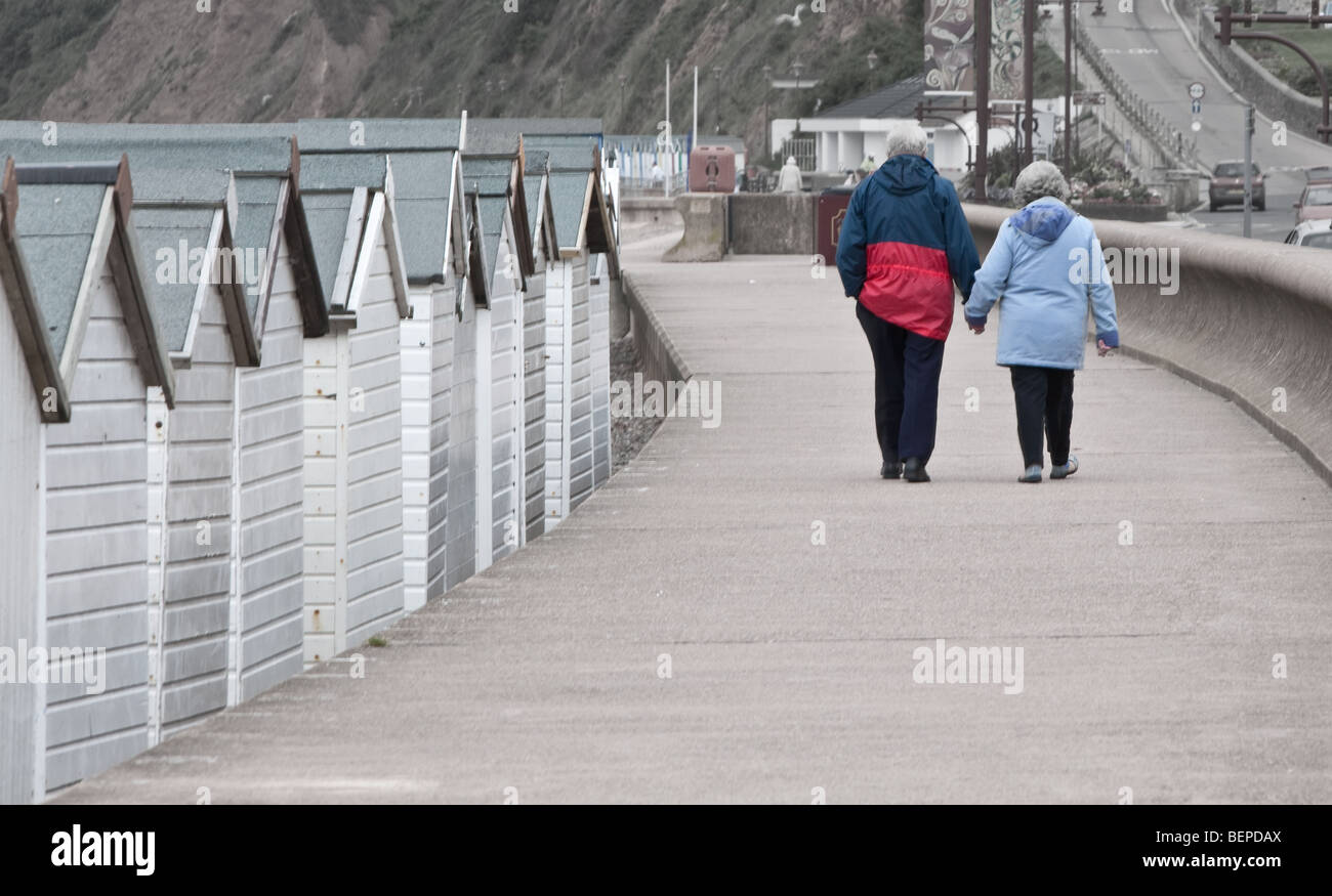 Young Love: Old couple strolling along the front in Seaton Stock Photo