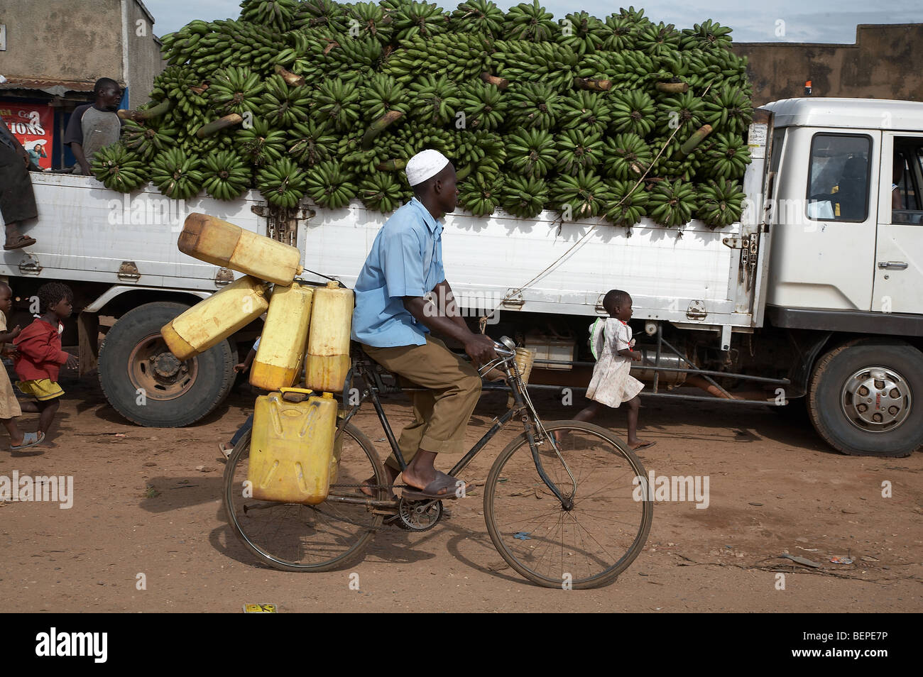UGANDA Truck of bananas and man carrying jerrycans on bicycle, Karagi