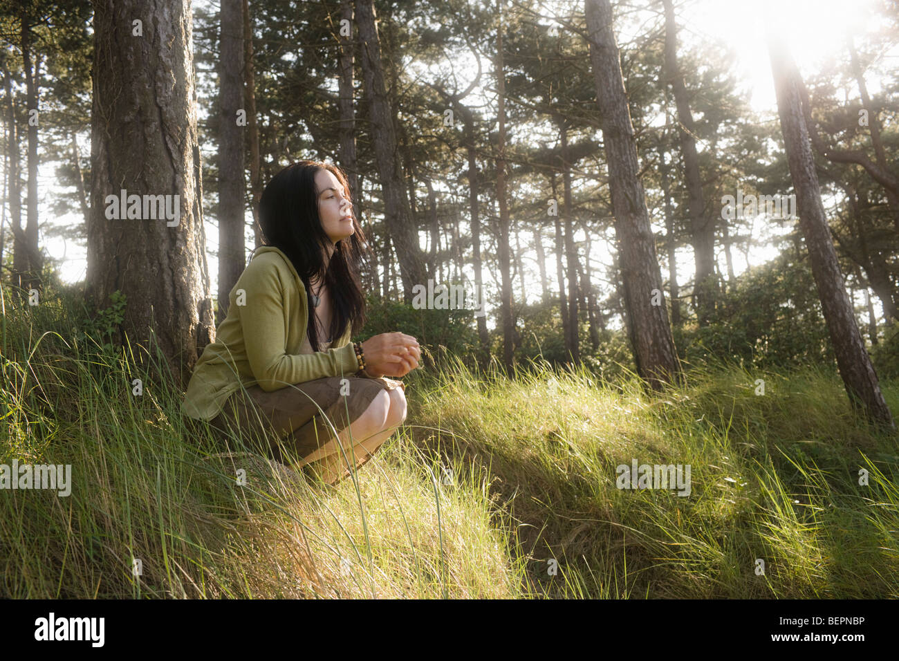 Woman crouching in contemplation Stock Photo
