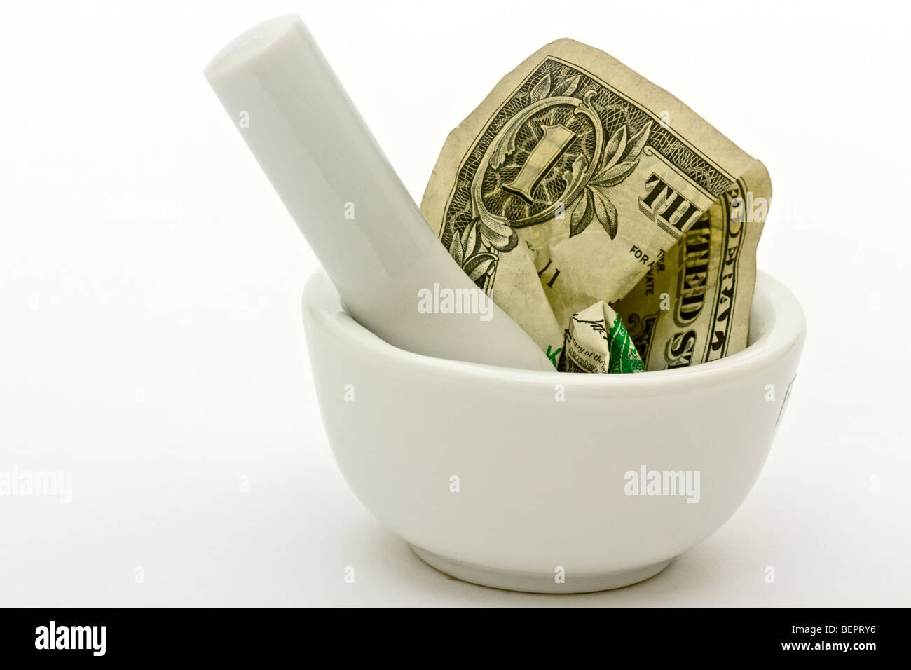 Mortar and pestle crushing a dollar bill Stock Photo Alamy