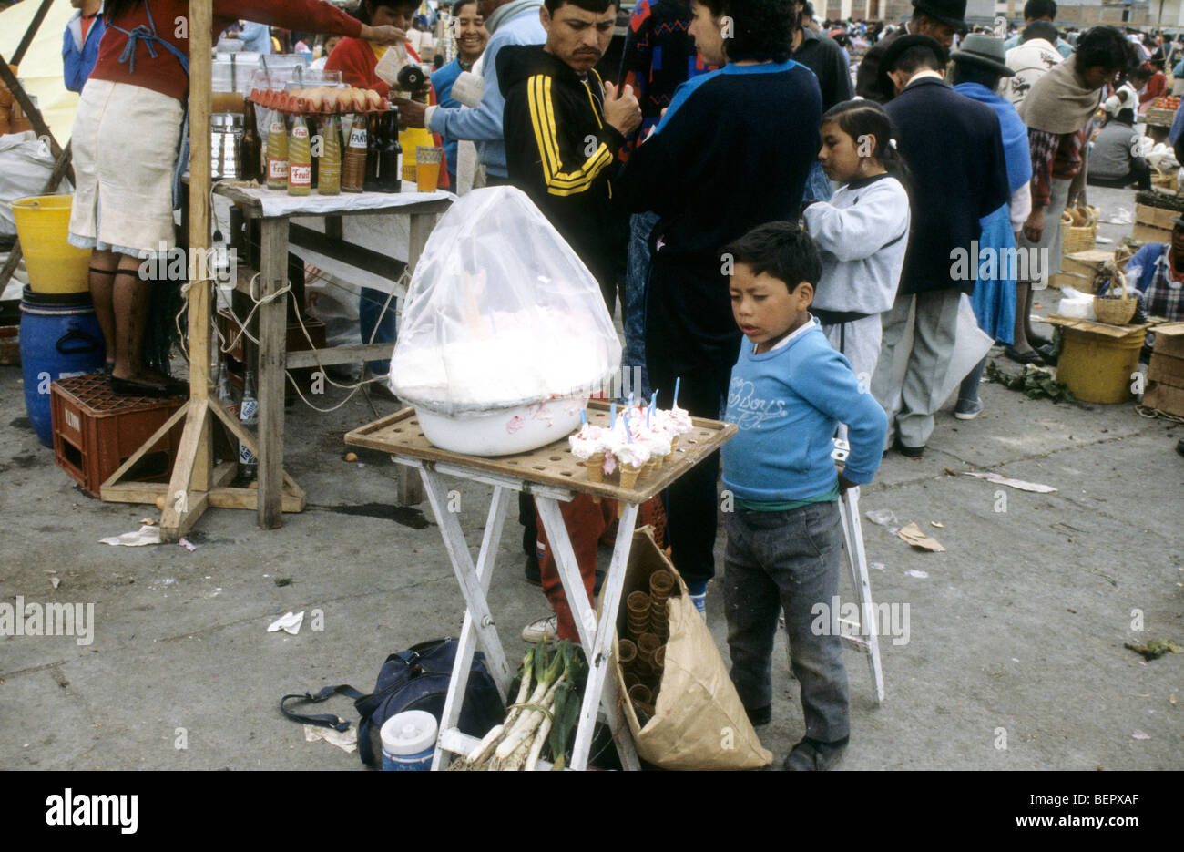 Young boy looks longingly at line of ice cream cones in local upland Ecuador market. Stock Photo