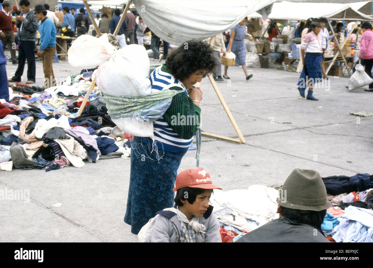Woman with half full sack of purchases on her back, local upland Ecuador market. Stock Photo