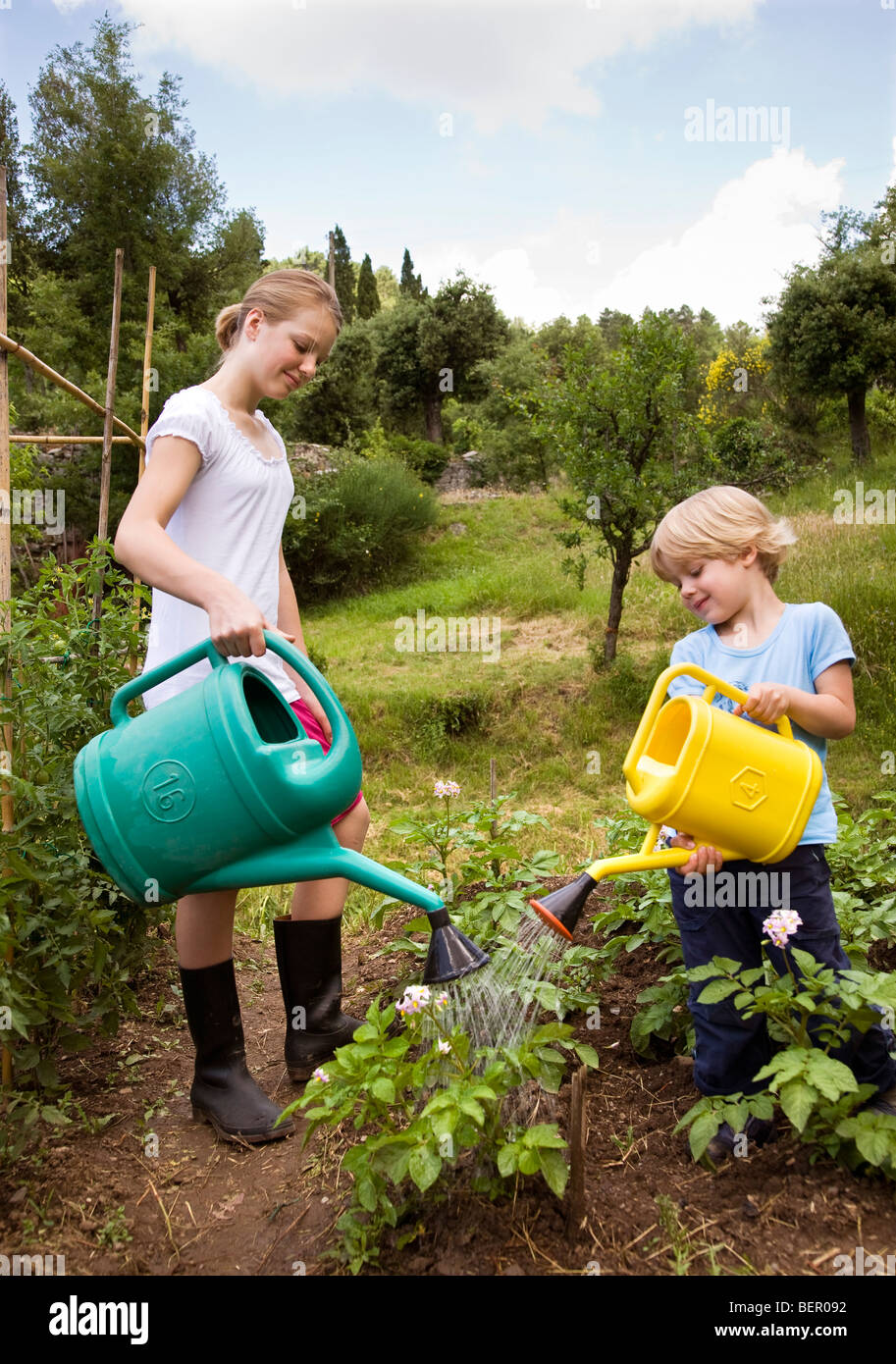 girl and boy watering plants Stock Photo - Alamy