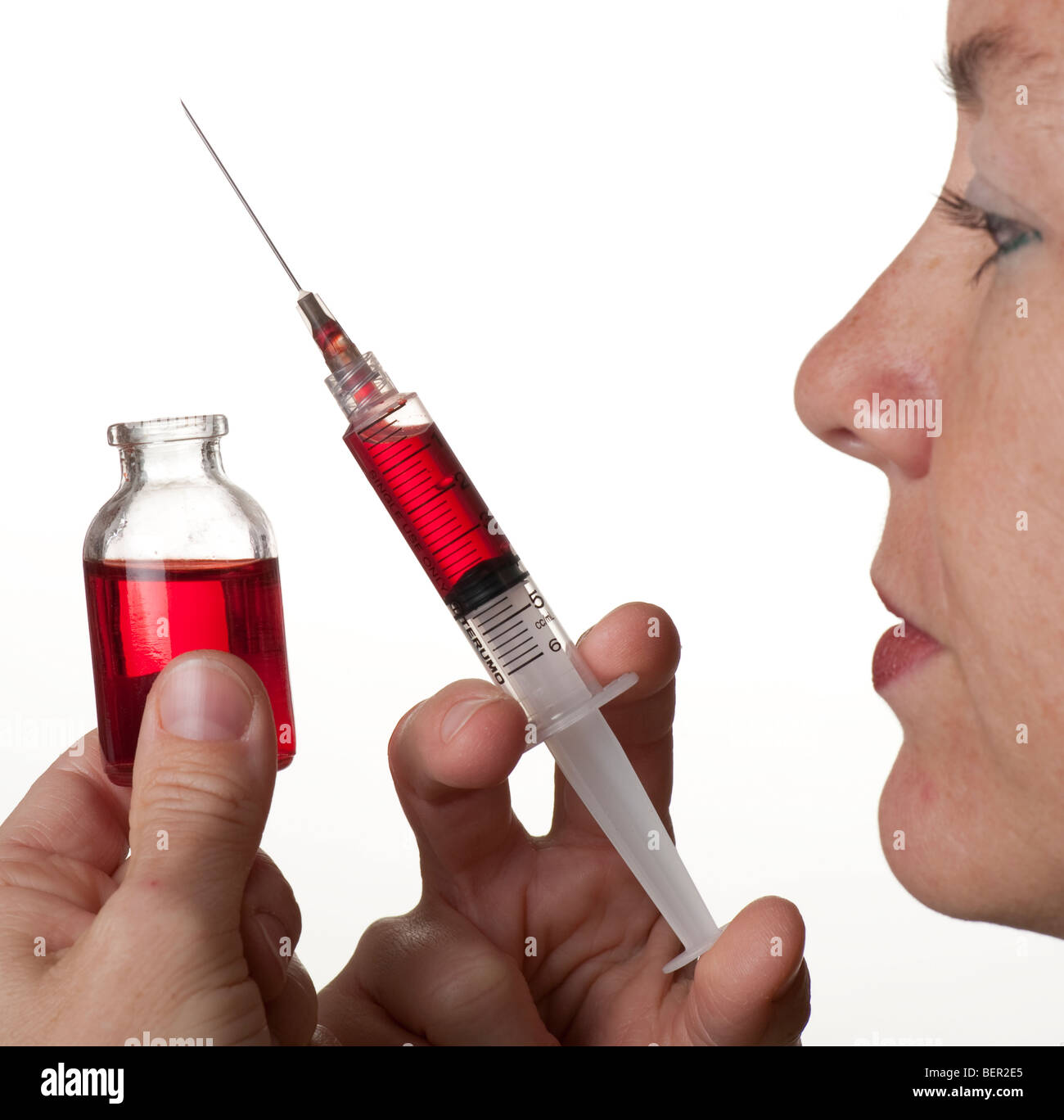 medical doctor holding hypodermic needle and vial Stock Photo