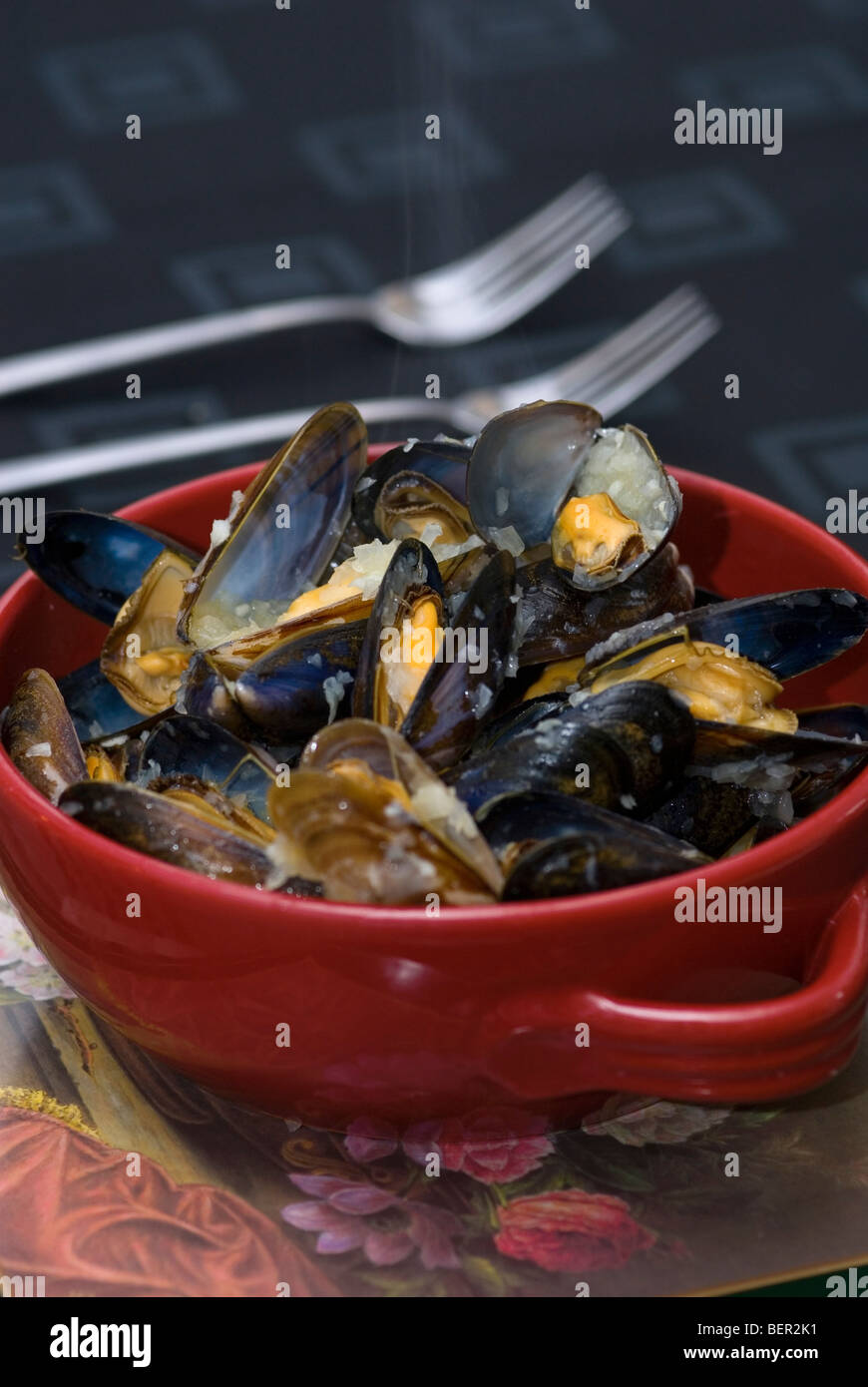 Cooked Mussels in red bowl Stock Photo