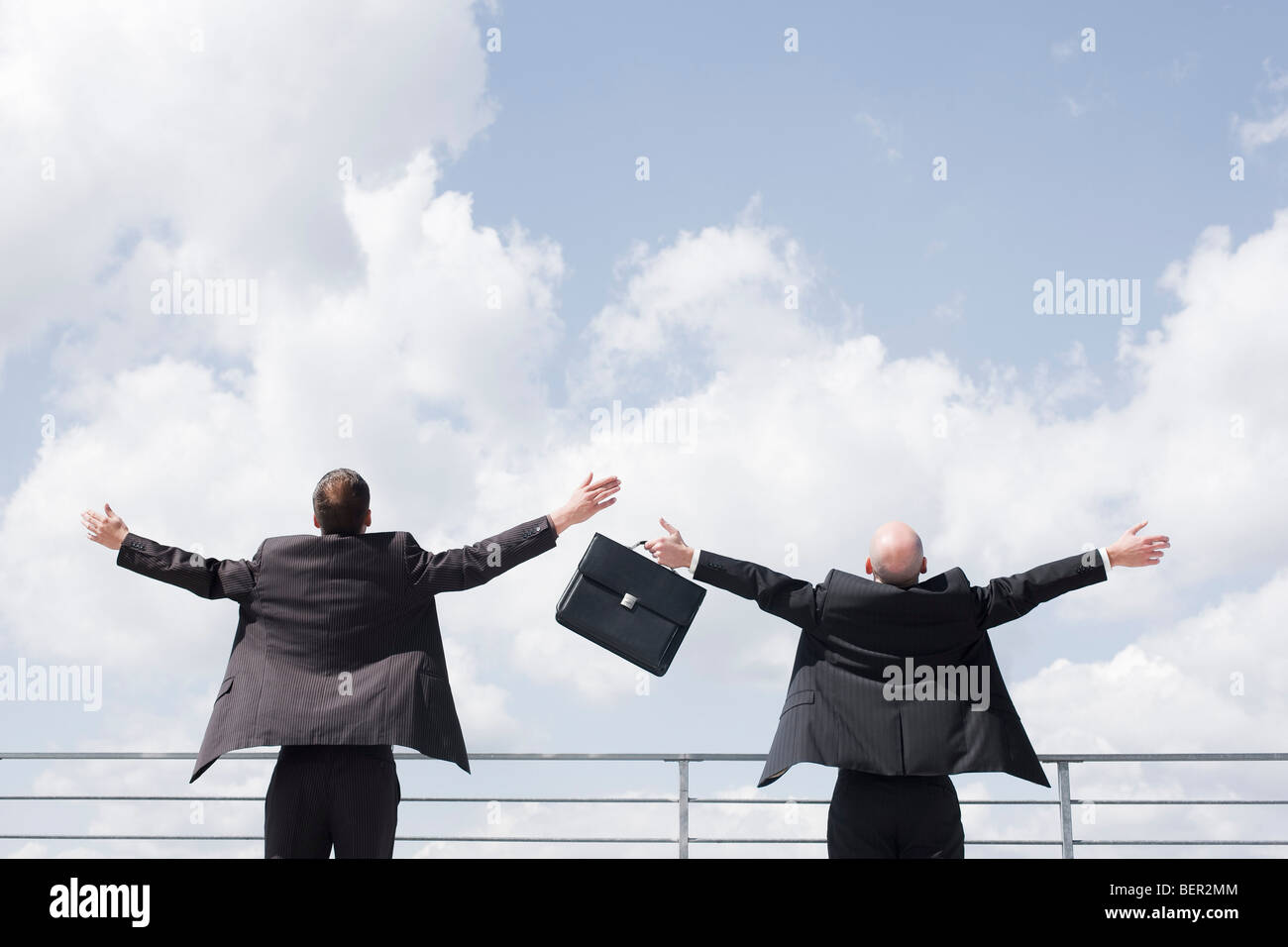 two business men throwing arms in sky Stock Photo Alamy