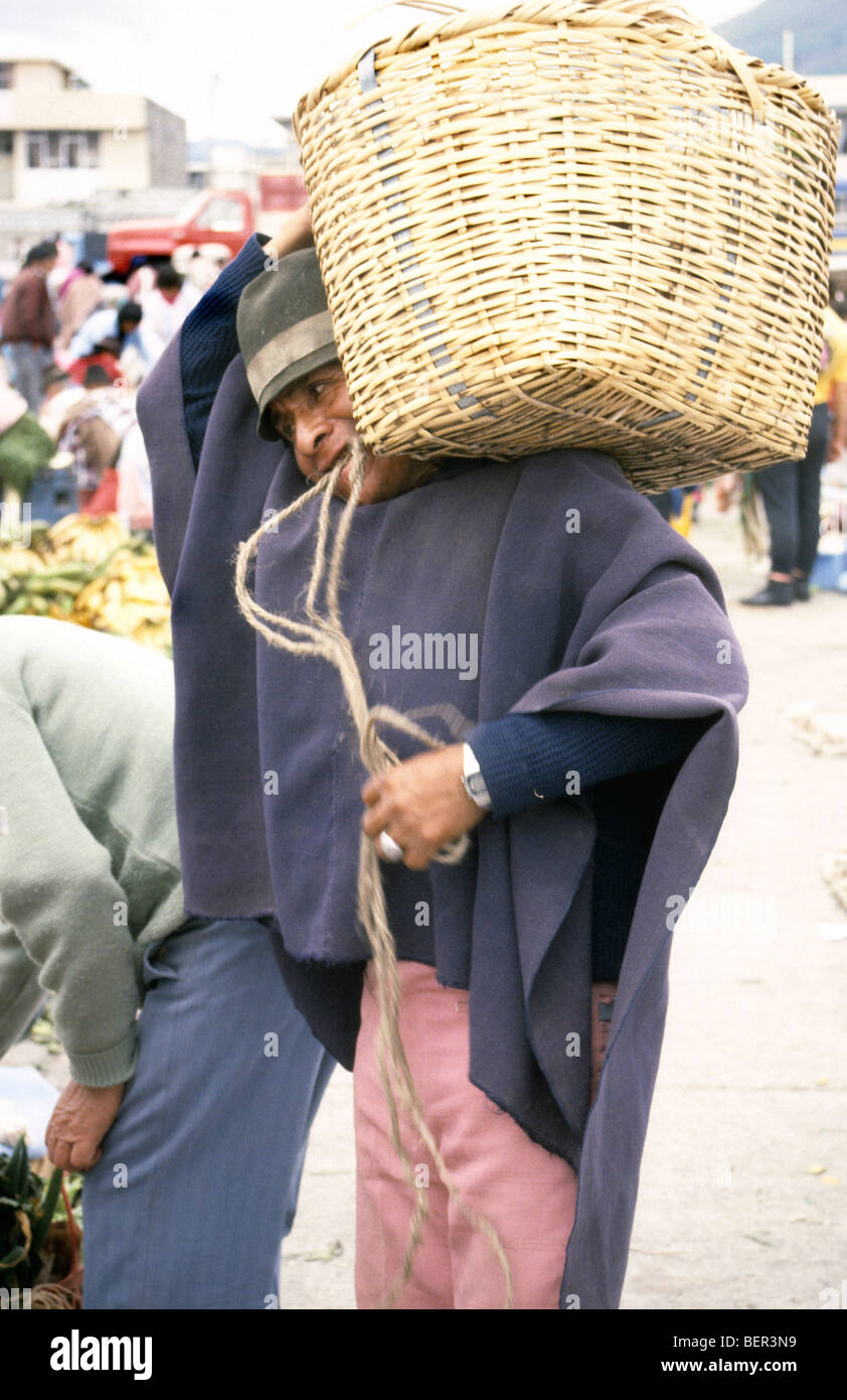 Man with huge heavy wicker basket balanced on his shoulder. Local market  upland Ecuador Stock Photo
