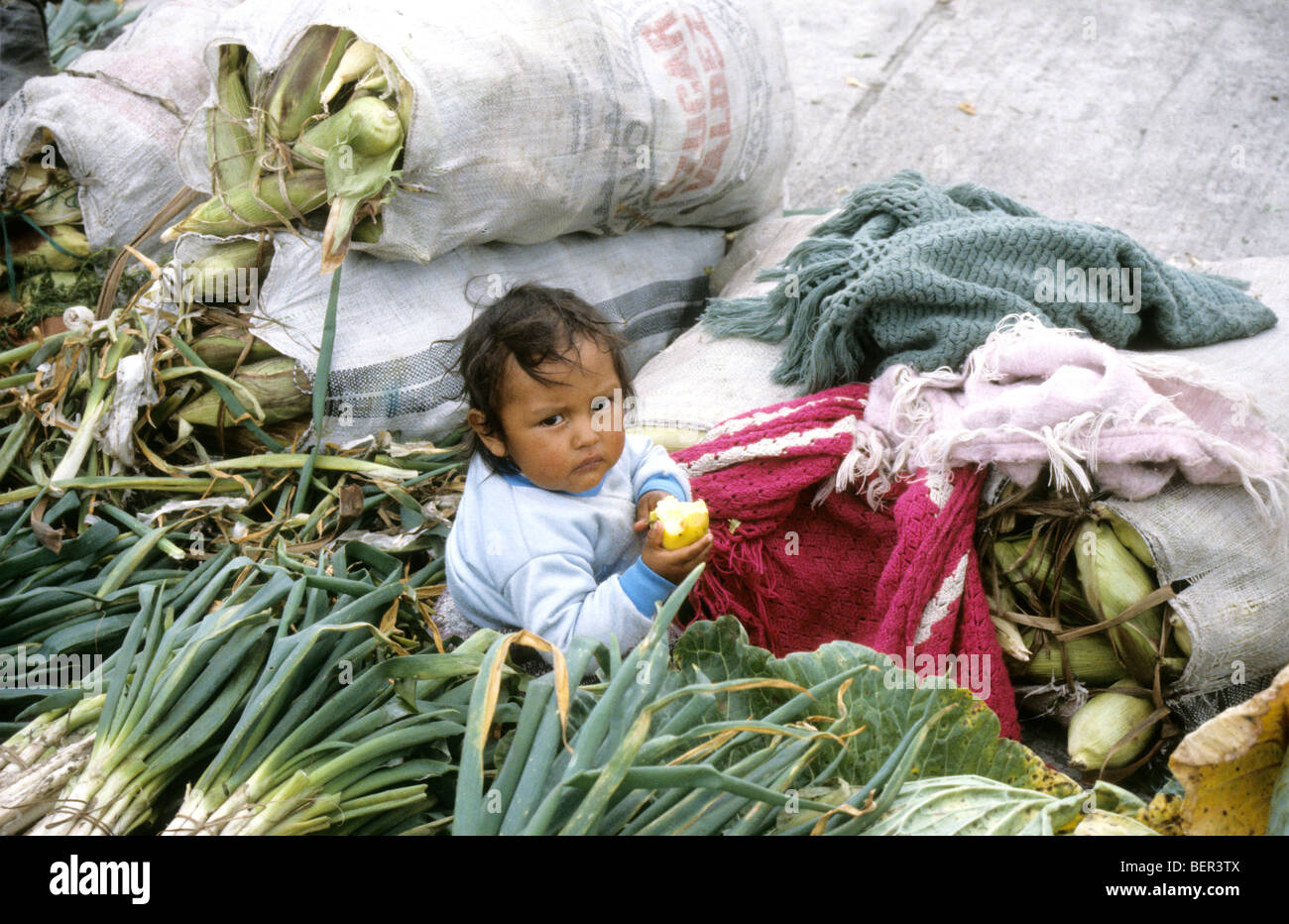 Small child amidst vegetables. Local market  upland Ecuador Stock Photo