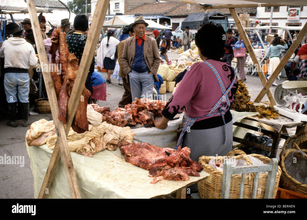 Meat seller  Piles and lumps of reddish unidentifyable meat lie on open stall.  Ecuadorian highland market Stock Photo