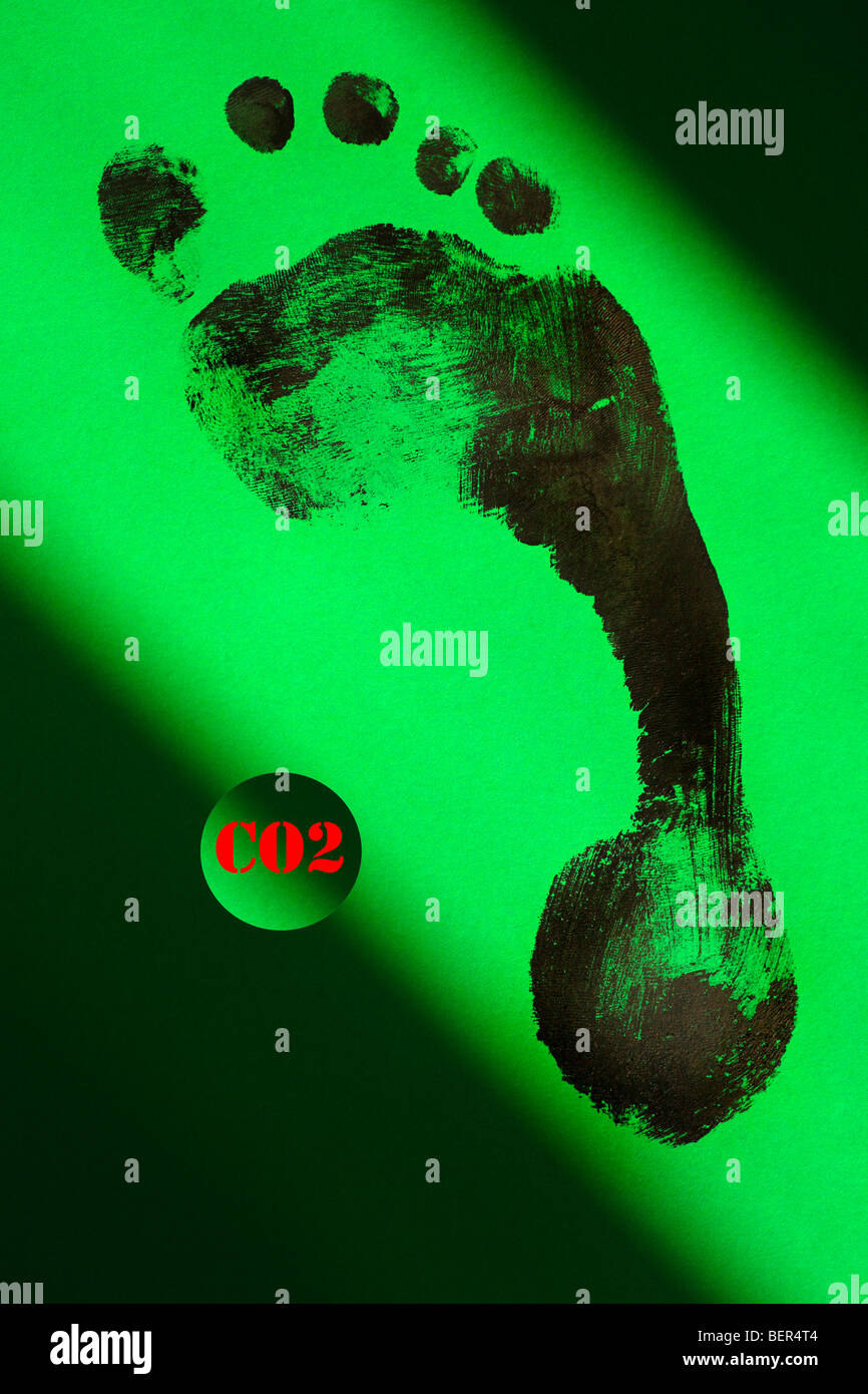 A black footprint on green symbolizing the carbon footprint with 'CO2' in red. Stock Photo