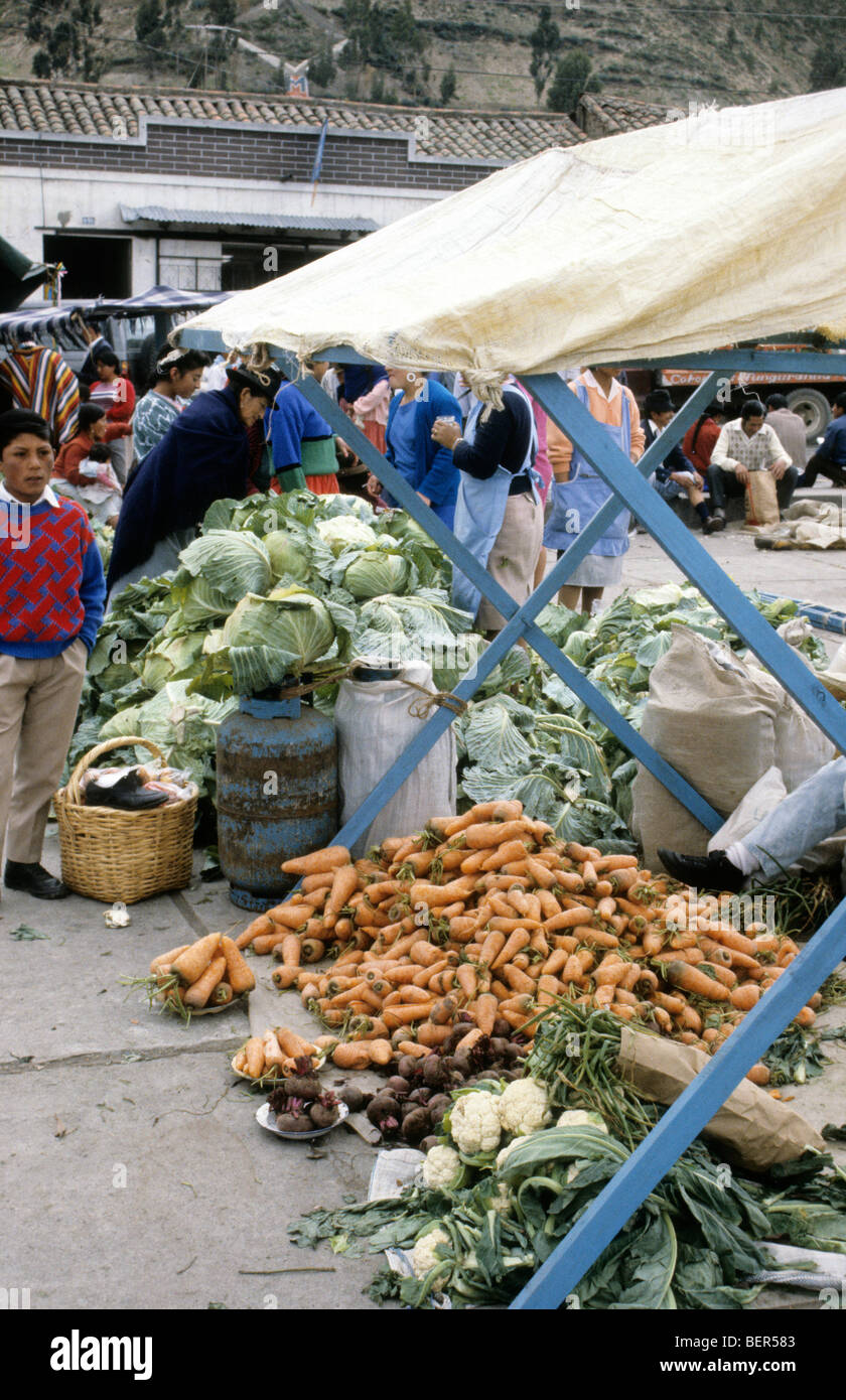 Huge pile of carrots under stall awning with few beetroot and cauliflowers in foreground.  Ecuador highlands local market. Stock Photo