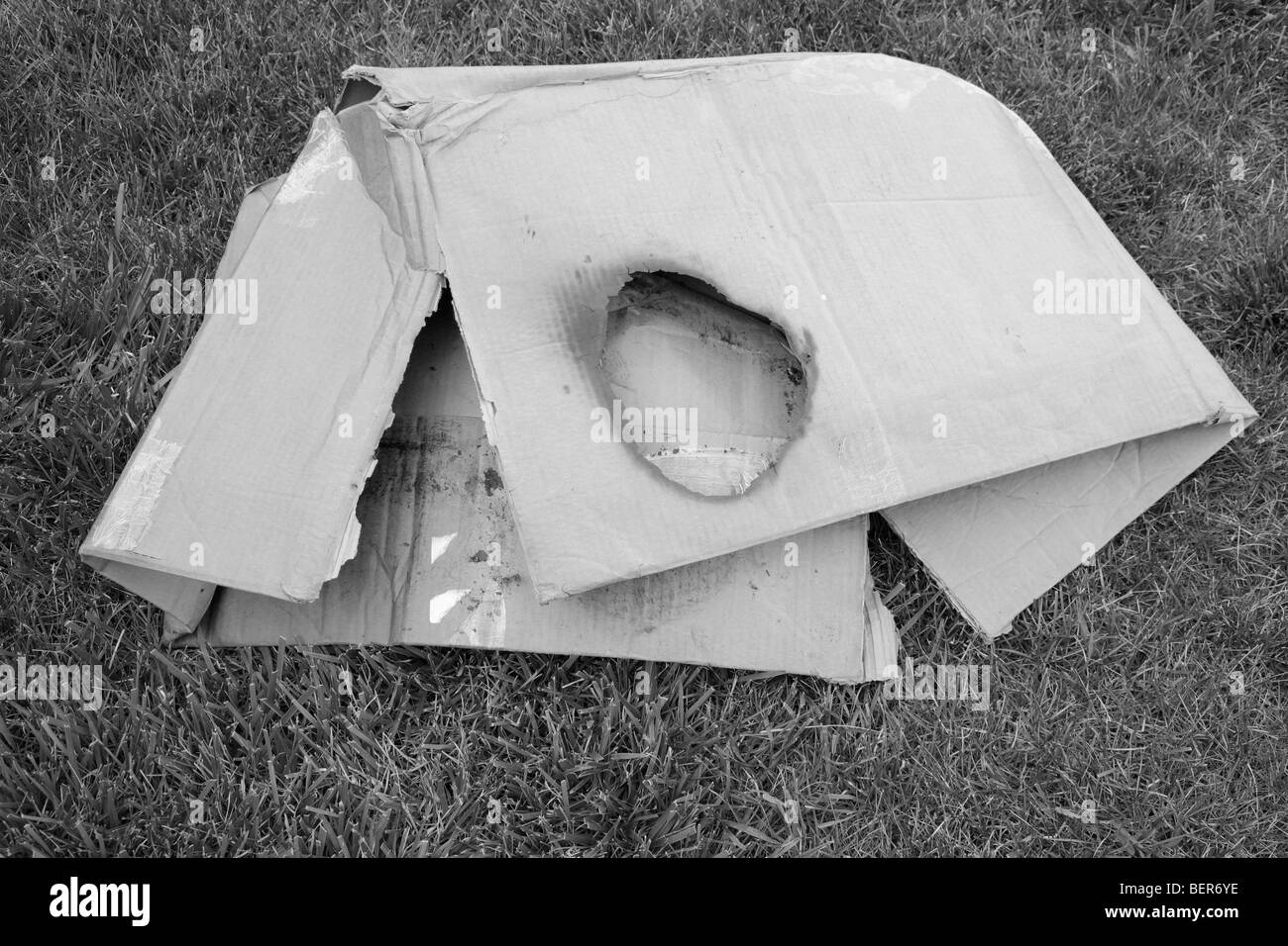 crushed and burned cardboard box with hole Stock Photo