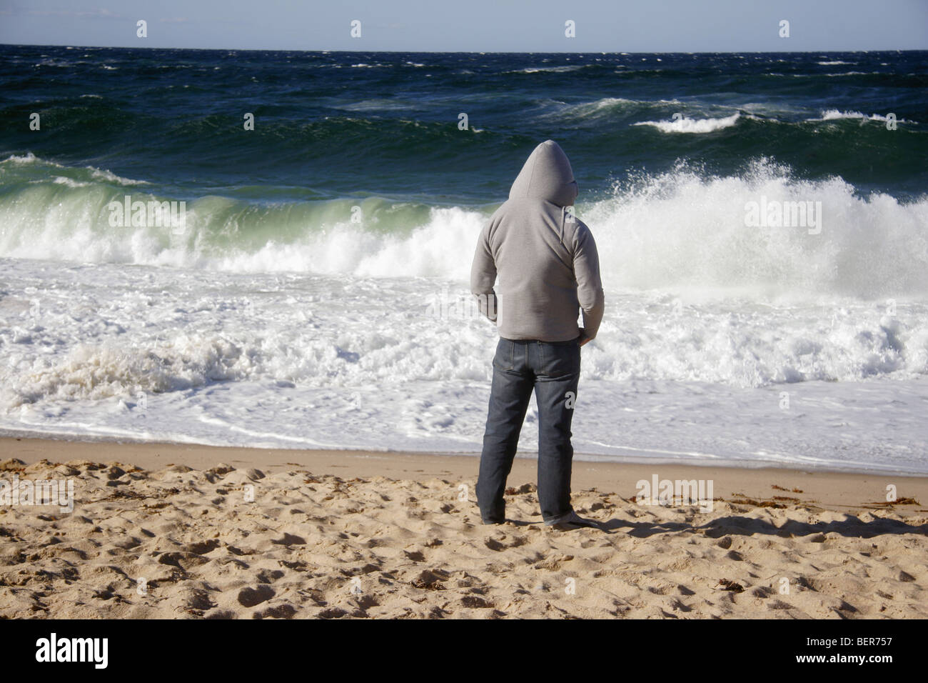 Man wearing hoodie on beach hi-res stock photography and images