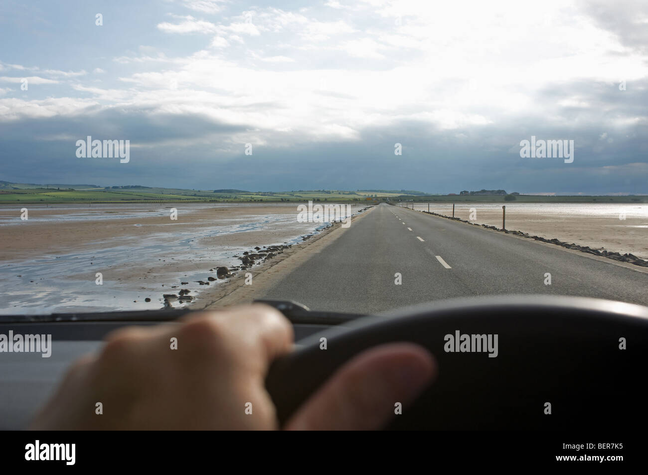 Driving on the causeway between the Holy Island of Lindisfarne and the mainland, Northumberland, UK. Stock Photo