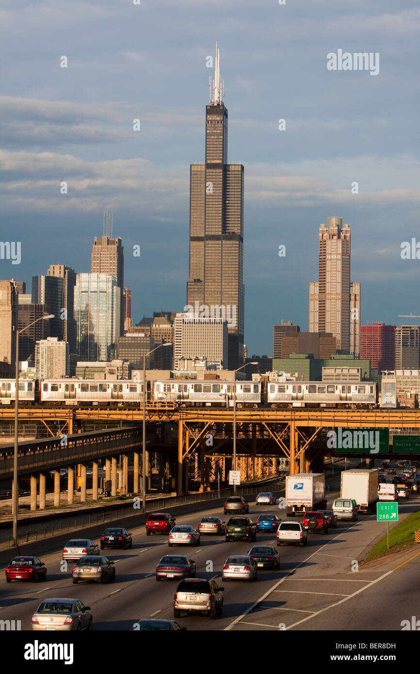 The Sears (Willis) Tower rises over the city of Chicago as rush hour traffic and L trains pass below. Stock Photo
