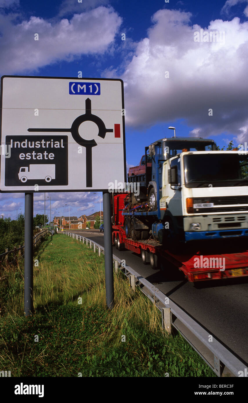 articulated lorry passing road sign giving directions for lorry drivers