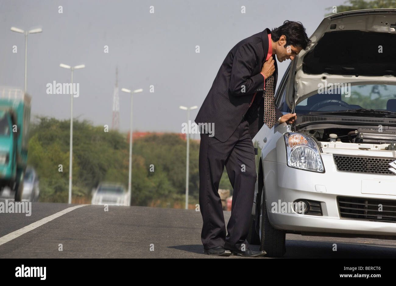 Executive stranded with a broken down car Stock Photo