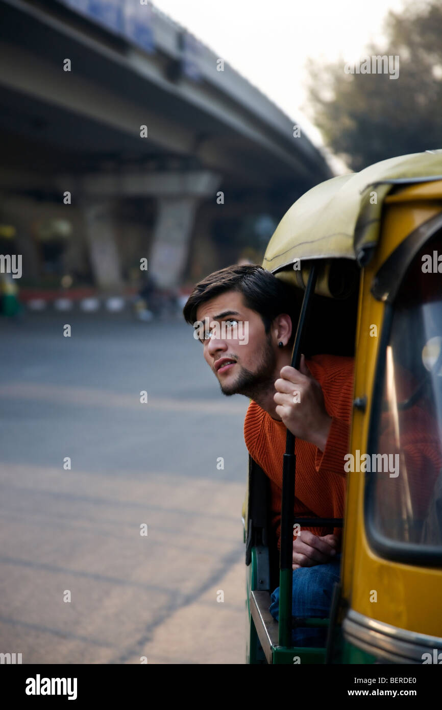 Man looking out of an auto rickshaw Stock Photo