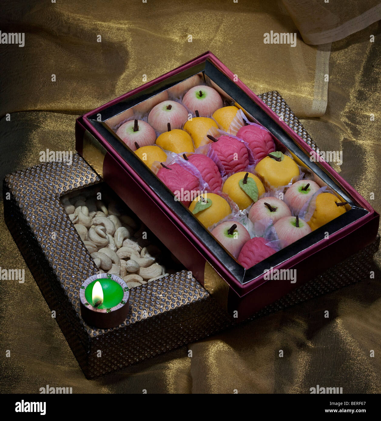 Box of sweets and nuts with a diya Stock Photo