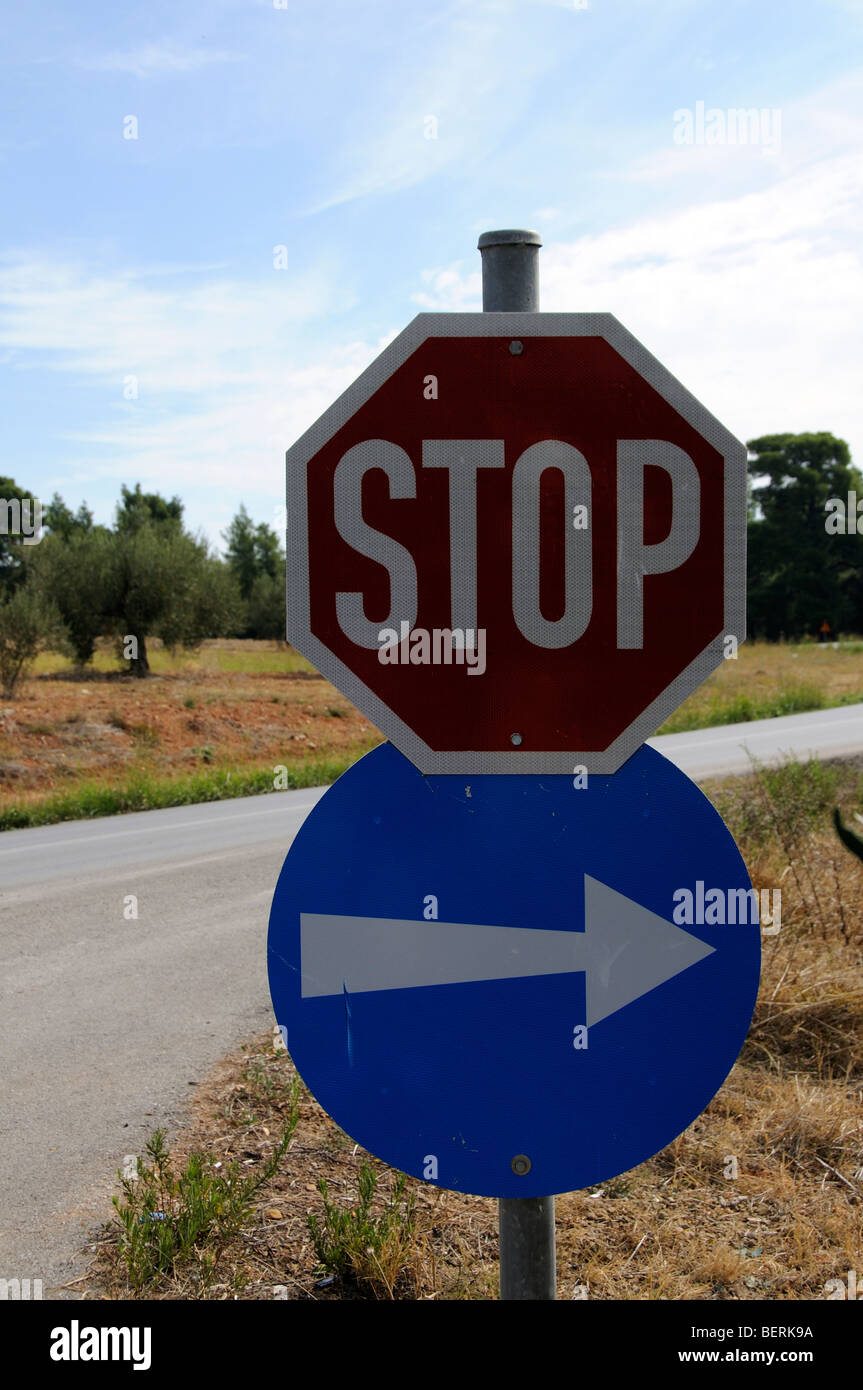Roadside traffic stop sign and direction arrow pointing right Stock Photo