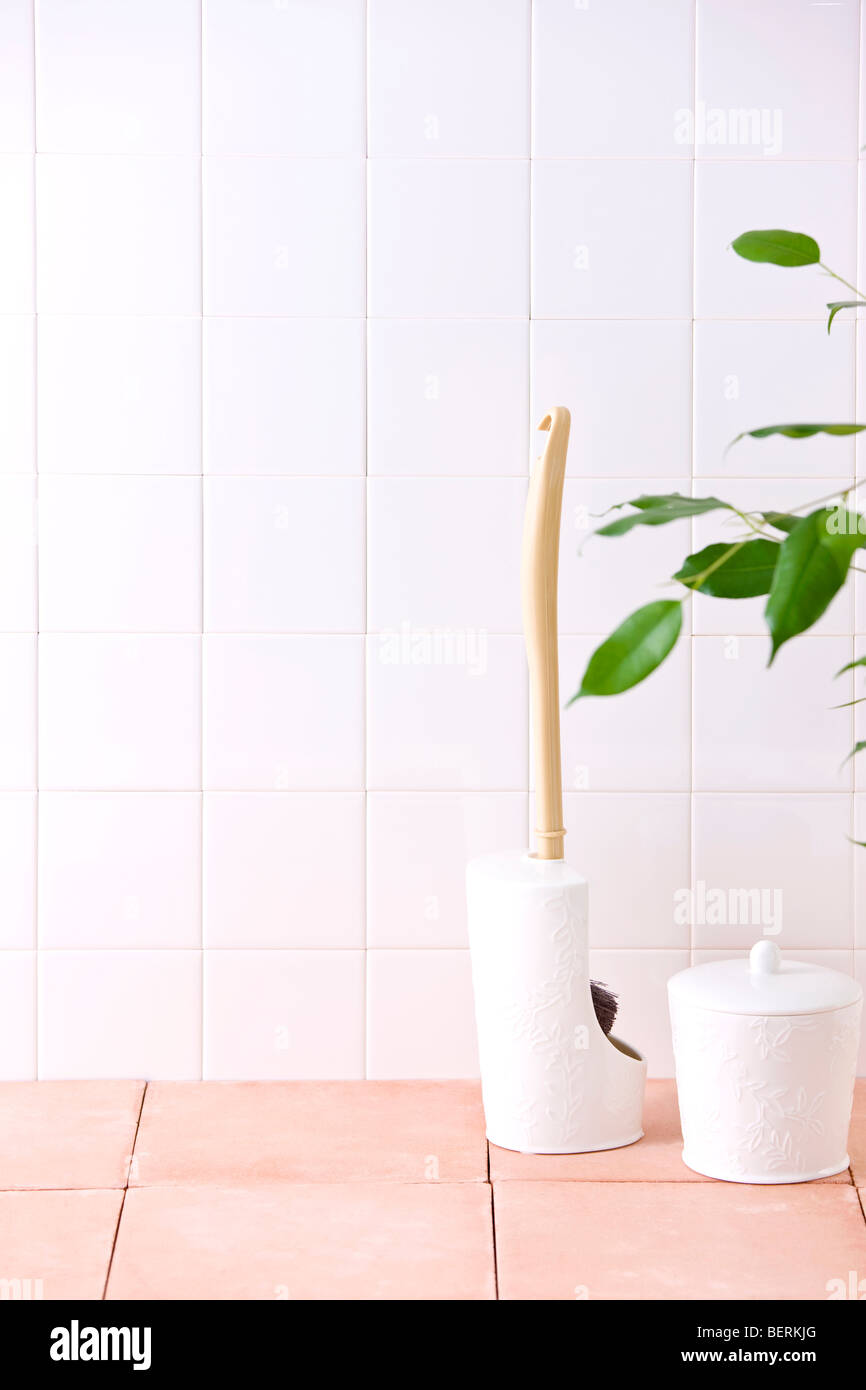 Toilet brush and garbage bin on floor Stock Photo