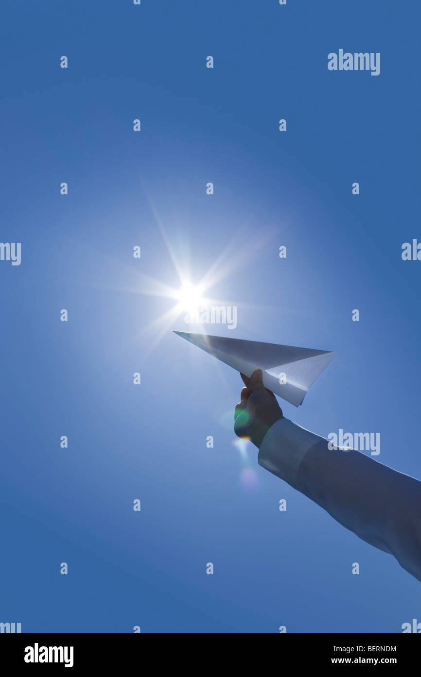 Person holding paper airplane Stock Photo