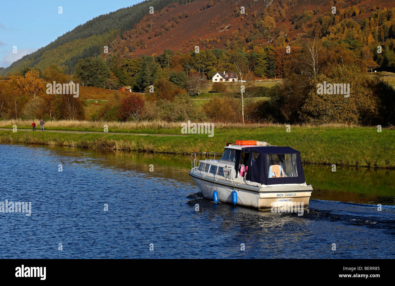 Small motor boat travelling on Caledonian Canal during autumn Aberchalder Scotland UK Europe Stock Photo