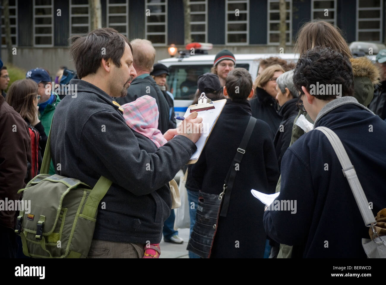 A volunteer, right, collects signatures on a petition in Brooklyn in New York Stock Photo