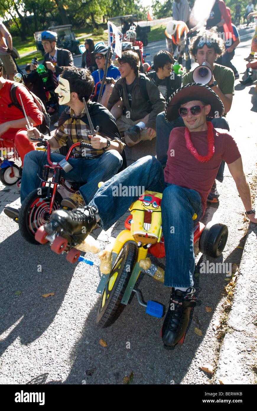 Participants in the 2nd Big Wheel Race in Central Park dangerously hurdle down hills in New York Stock Photo