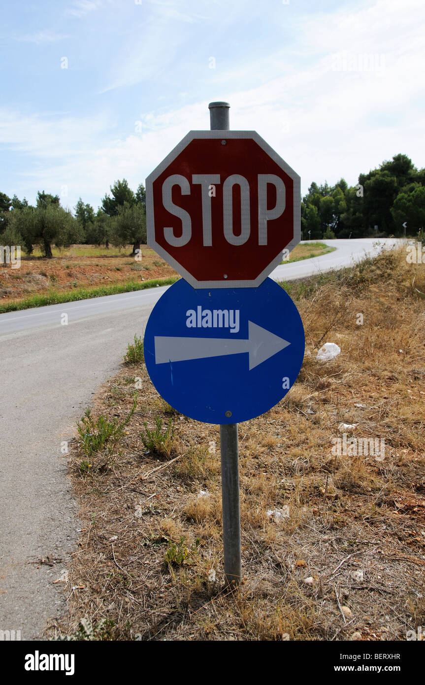 Roadside traffic stop sign and direction arrow pointing right Stock Photo