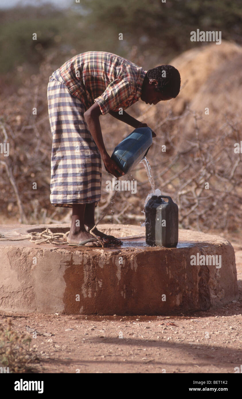 Somali boy filling water can from a borehole, Wajir, Somaliland, Kenya Stock Photo