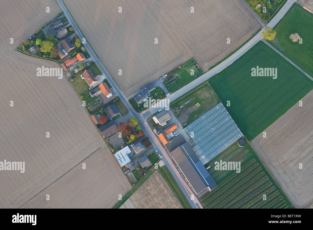 Urbanisation at the border of agricultural area with fields, grasslands and hedges from the air, Belgium Stock Photo