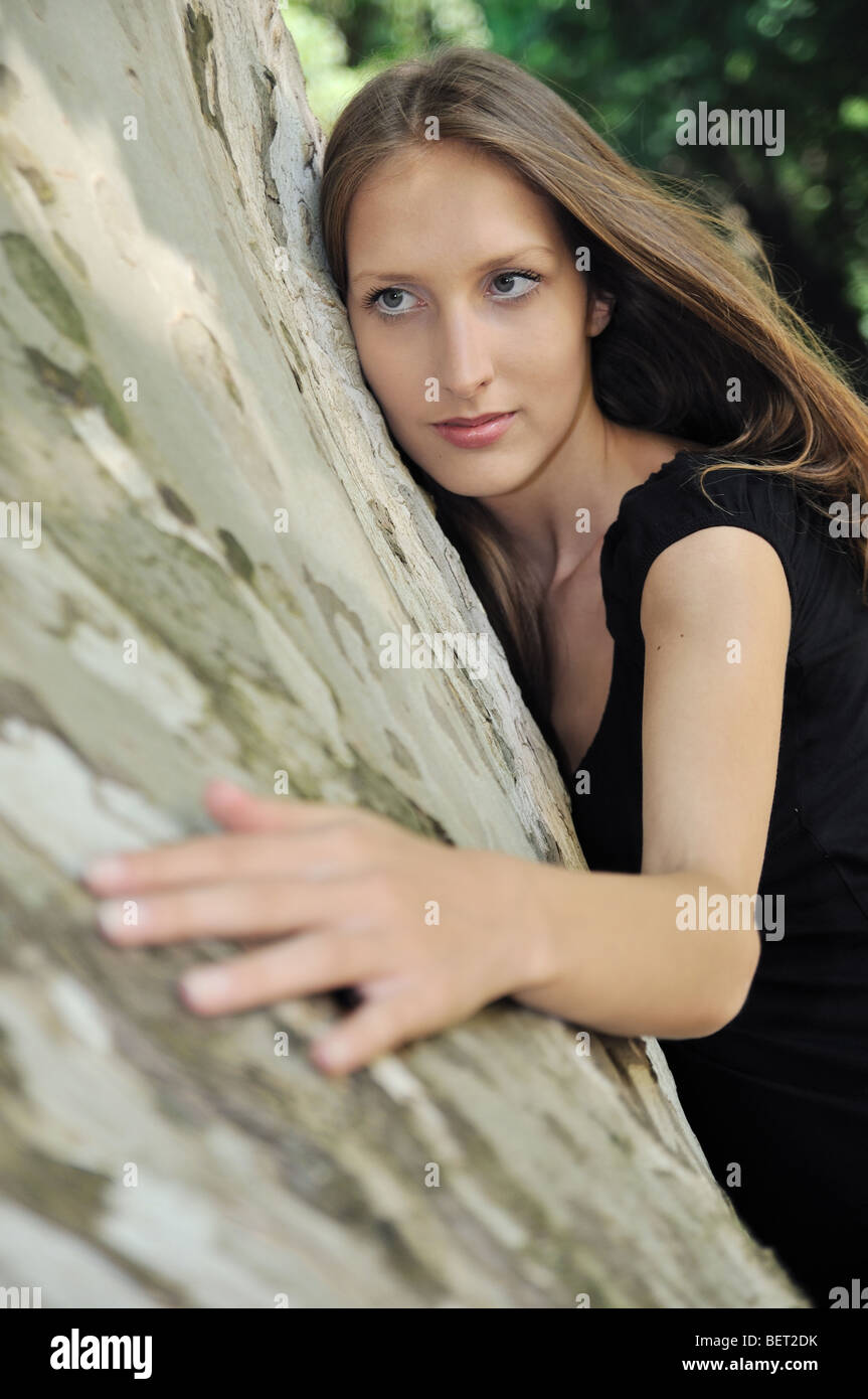 Young woman huging trunk of tree - love to nature Stock Photo