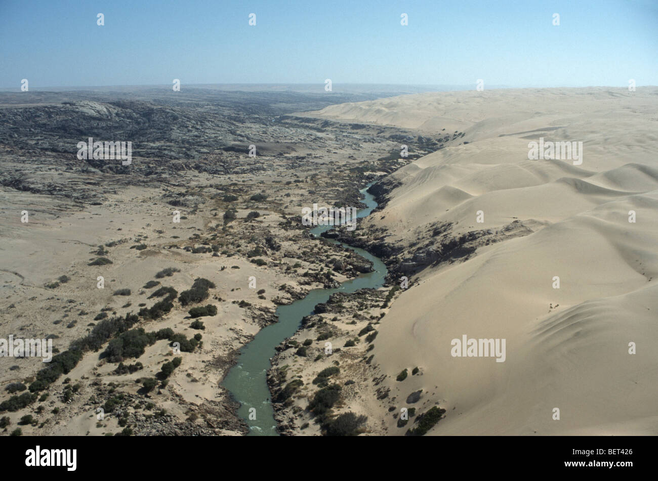 Sand dunes cut through by the Cunene River in the Namib desert, Northern Namibia. Angola is on the left hand side. Stock Photo