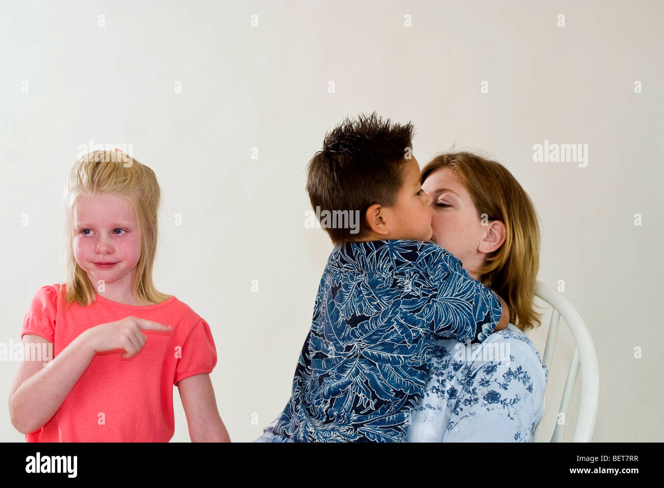 single mom holding newly adopted 3 year old Hispanic foster son while new sister is crying Caucasian emotional emotions emotion MR © Myrleen Pearson Stock Photo