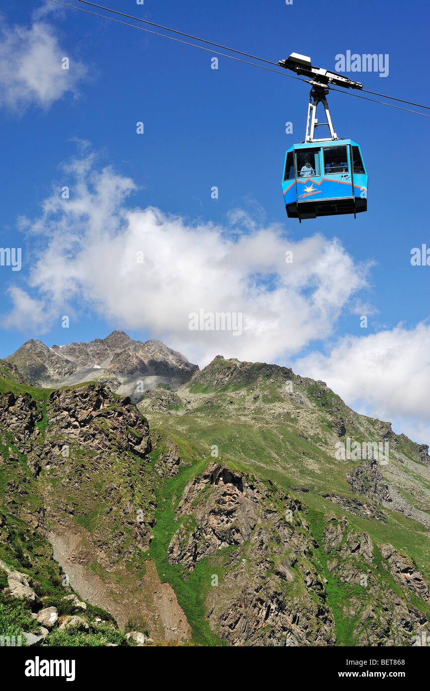 Tourists in cable car / cableway / cable-lift on a cloudy day in the mountains, Swiss Alps, Switzerland Stock Photo