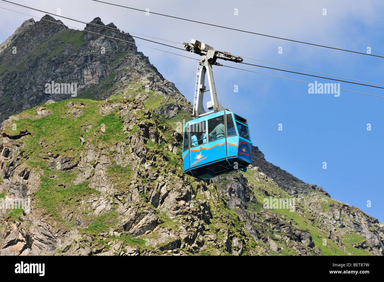 Tourists in cable car / cableway / cable-lift on a cloudy day in the mountains, Swiss Alps, Switzerland Stock Photo